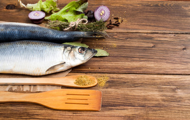 fresh fish with vegetables and spices, cooking seafood. On a wooden background. For restaurants