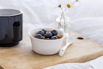 Breakfast in bed with coffee cereals and cranberries