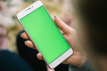 Beautiful girl holding a smartphone in the hands of a green screen green screen, hand of man holding mobile smart phone with chroma key green screen on white background, new technology concept