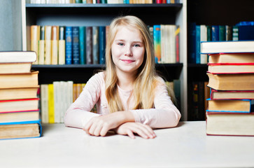 Smiling teenage girl between stack of book