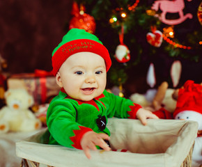 The small boy sitting near Christmas Tree