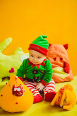 The small boy sitting near orange toys