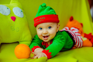 The small boy with mandarins lies on the sofa