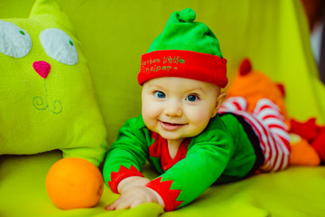 The small boy with mandarins lies on the sofa