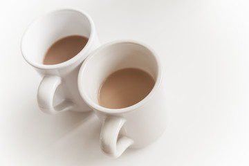 Two big cups full of coffee with milk