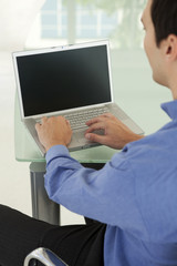 Single Caucasian businessman using laptop in office