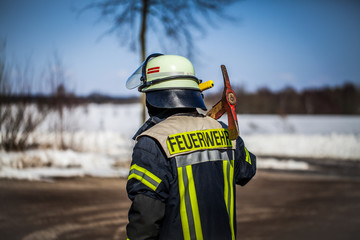 HDR - Feuerwehrmann im Einsatz draußen auf der Straße mit einer Axt