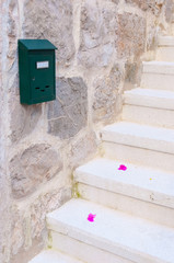 Stone stairs with petals and mailbox. Entrance to housing upstai