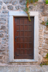Fairy old wooden door in stone wall. Retro style entrance in Bud