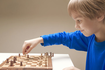 Smiling child playing a game of chess