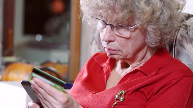 Senior woman in sofa websurfing on internet