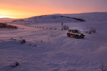 Car on the arctic road in day time. Murmansk Region, Russia