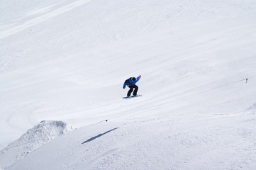 Fototapeta na wymiar Snowboarder jumping in terrain park at ski resort on sun winter