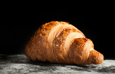 Fresh croissant on scratched background