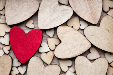 Wooden hearts, one red heart on the heart background.