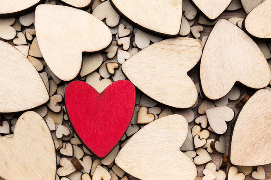 Wooden hearts, one red heart on the heart background.