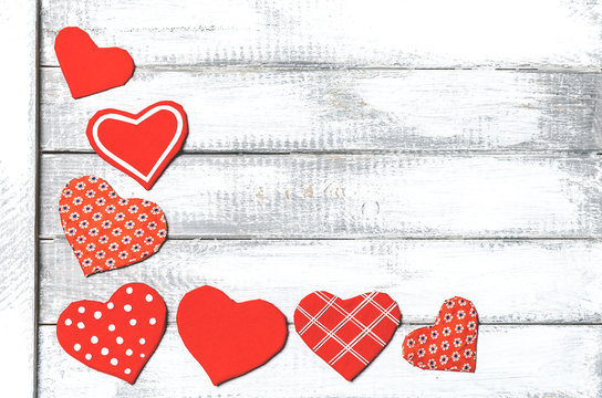 handmade toy hearts on a white wooden background. Valentine day background