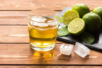 glass of whiskey on wooden background