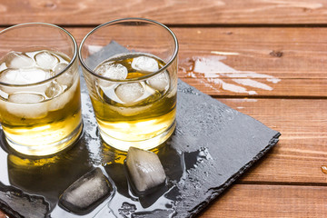 glass of whiskey on wooden background