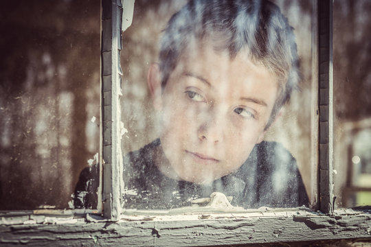 Boy Looking Out A Window