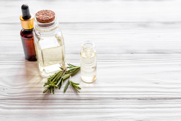 organic cosmetics with extracts of herbs rosemary on wooden background