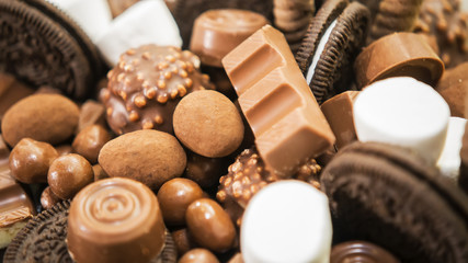 Mix of chocolate, candies, and cookies on table