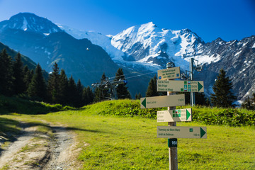 A trail sign indicates different trails in the mountains above Chamonix, France