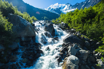 A waterfall fed by glacial meltwater flowing off the Glacier du Bionnassay in the French Alps