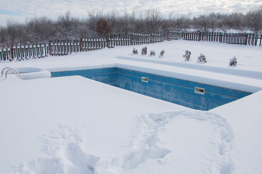 Ice Swimming Pool In The Winter, Steps, Hand-rails And Garden Chair In The Frozen Blue Pool Ice-hole