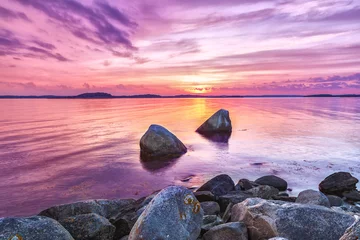 Fotobehang Fluor Roze Schilderachtig zeezonsonderganglandschap met grote stenen op de voorgrond. Violette toning van mooie schemerscène. Kleur in de natuur concept.  © Feel good studio