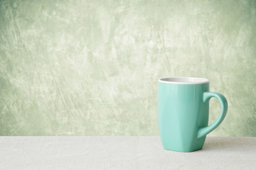 Green coffee cup on sack tablecloth over blur green park