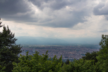View of Turin through green trees. Remembrance park. Piedmont Italy.