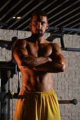 Fototapeta na wymiar Serious Young Bodybuilder Standing In The Gym