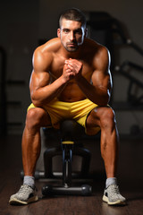 Fototapeta na wymiar Man Rests In Gym After Having A Workout