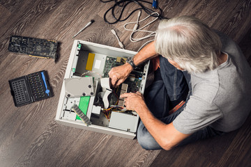 Senior Man Assembling A Desktop Computer
