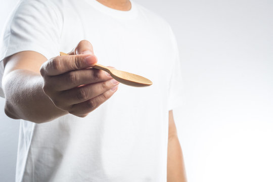 Man hand holding a wooden spoon
