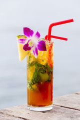 Refreshing drink with lime, mint and pineapple on a tropical beach