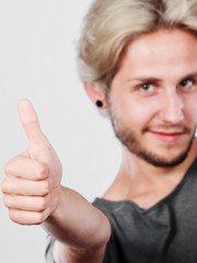 Content young man giving thumb up