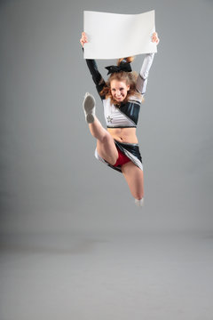 Young Cheerleader On Gray Background