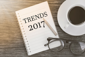 Concept Trends 2017 message on notebook with glasses, pencil and