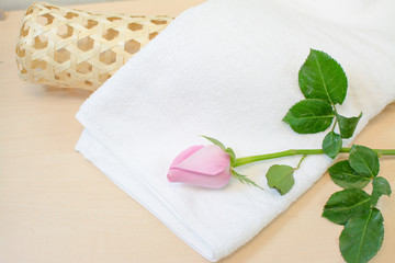 white towel and pink rose on wood background