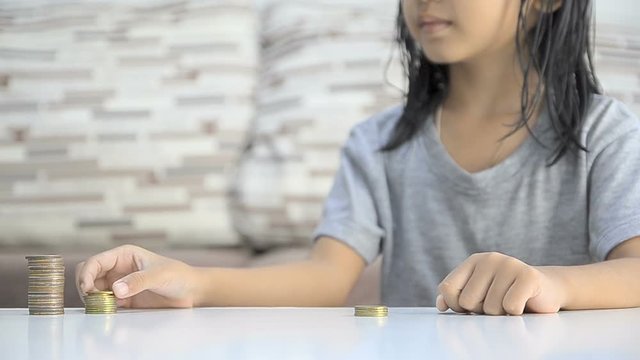 Asian little girl stacking coins