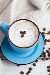 cappuccino and coffee beans on a wooden background