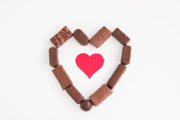 White background with chocolate heart and cardboard hearts.