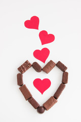 Valentines background with chocolate and red hearts.