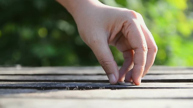 HD Hand of woman stacking coins over nature green leaf background