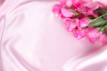 a bouquet sweet pink roses petal on soft pink silk fabric , roma