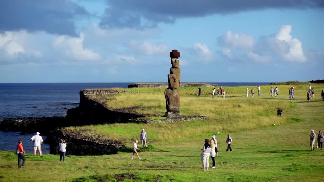 Tourists descend on Easter Island statue.