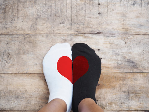  feet wearing white and black socks with red heart shape