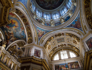 Fototapeta na wymiar Colorful artwork and gold embellishments on the ceiling and cupola of St. Isaac's Cathedral, a Russian Orthodox Church in St. Petersburg.